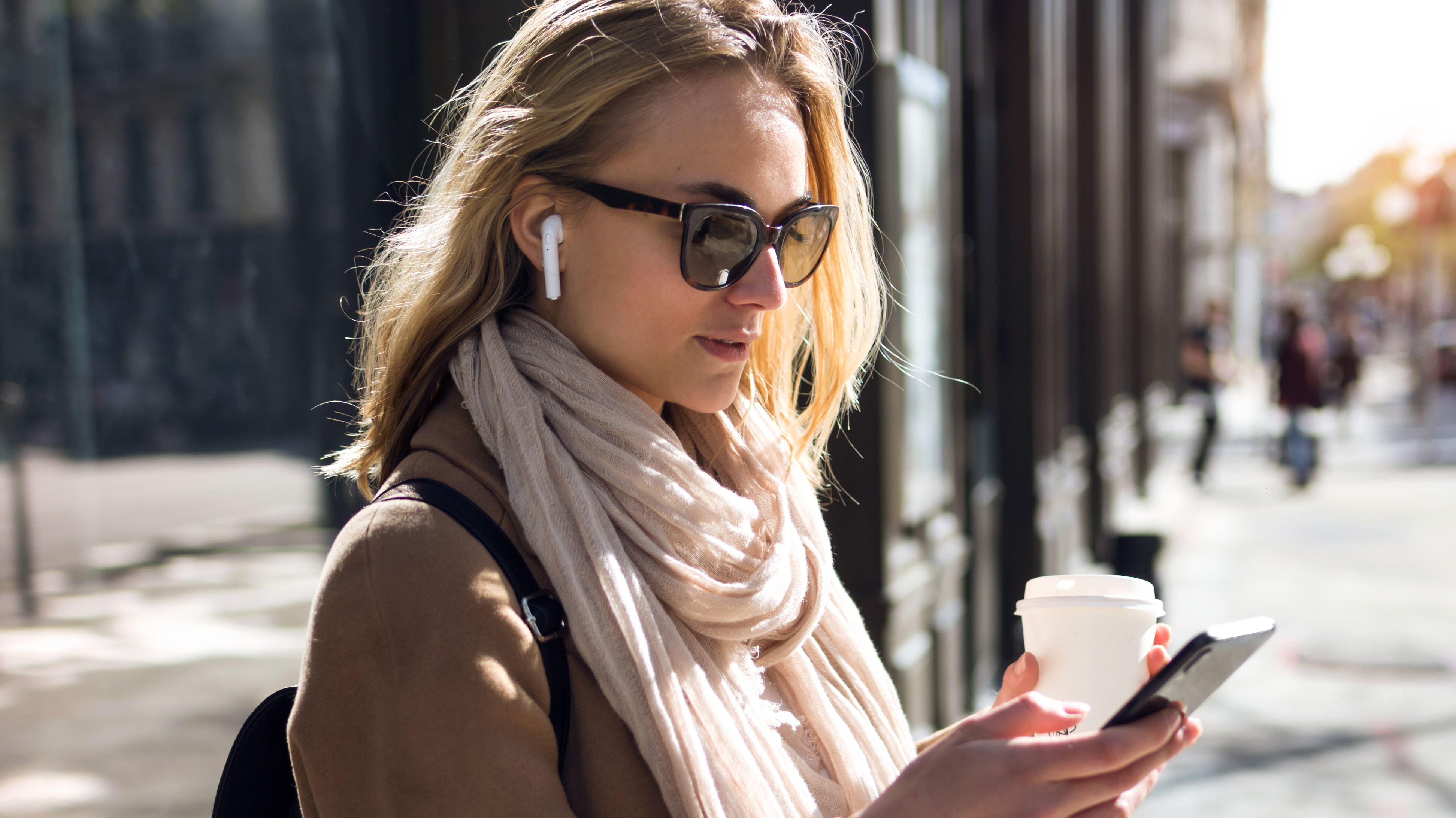 ragazza con auricolari che guarda lo smartphone